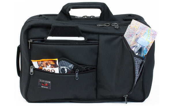 A front shot of the a Black 1050 Ballistic exterior Western Flyer with a map, tablet, snacks, and a pouch with cables in the front zippered pockets.